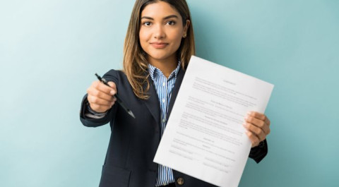 confident-young-female-professional-with-contract-pen-against-colored-background.jpg