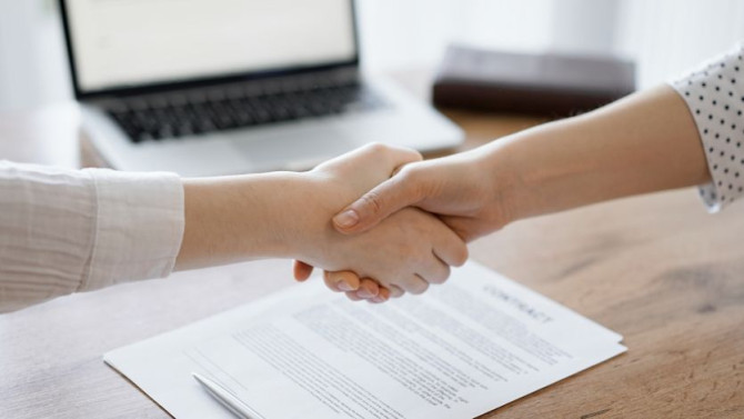 business-people-shaking-hands-contract-papers-just-signed-wooden-table-close-up-lawyers-meeting-teamwork-partnership-success-concept.jpg