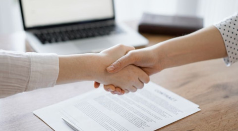 business-people-shaking-hands-contract-papers-just-signed-wooden-table-close-up-lawyers-meeting-teamwork-partnership-success-concept.jpg