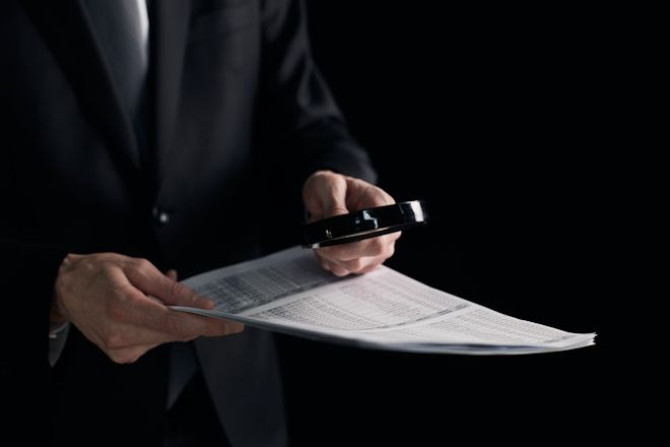 young-businessman-looking-contract-through-magnifying-glass.jpg