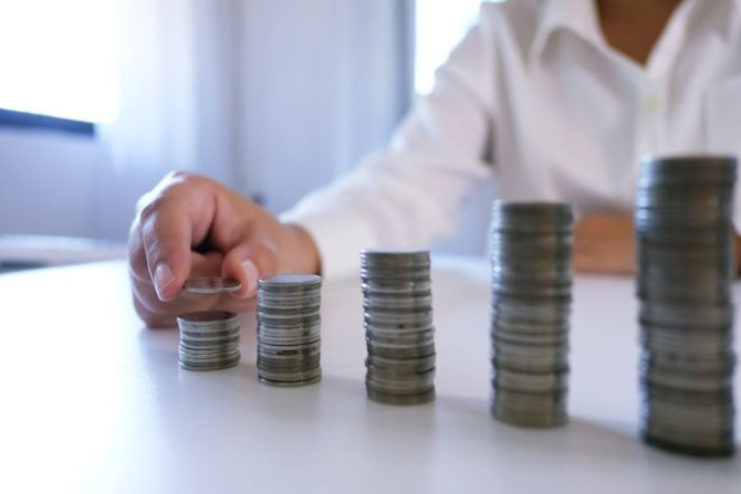 midsection-businesswoman-stacking-coins-table-office.jpg