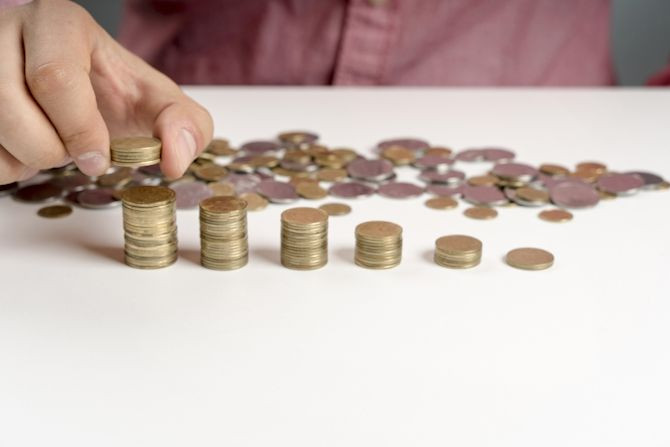 high-angle-man-arranging-stack-coins.jpg